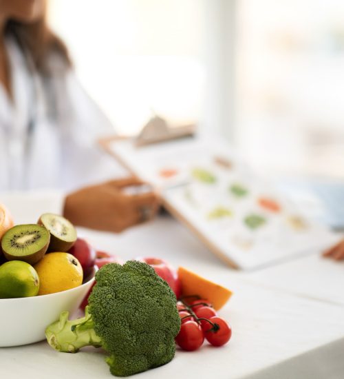 mature-caucasian-doctor-nutritionist-white-coat-recommends-young-woman-diet-plan-table-with